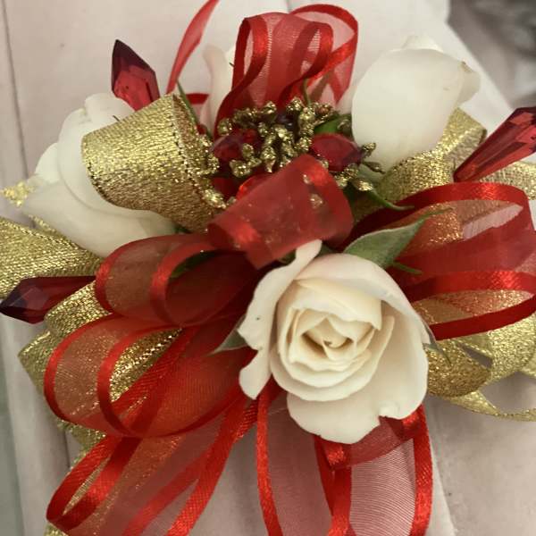 White rose corsage with red and gold ribbon accents