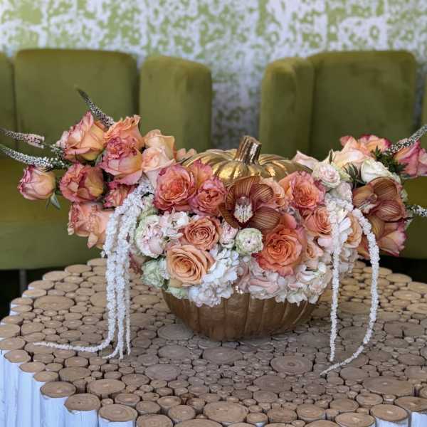 Peach and pink floral arrangement in a gold pumpkin vase