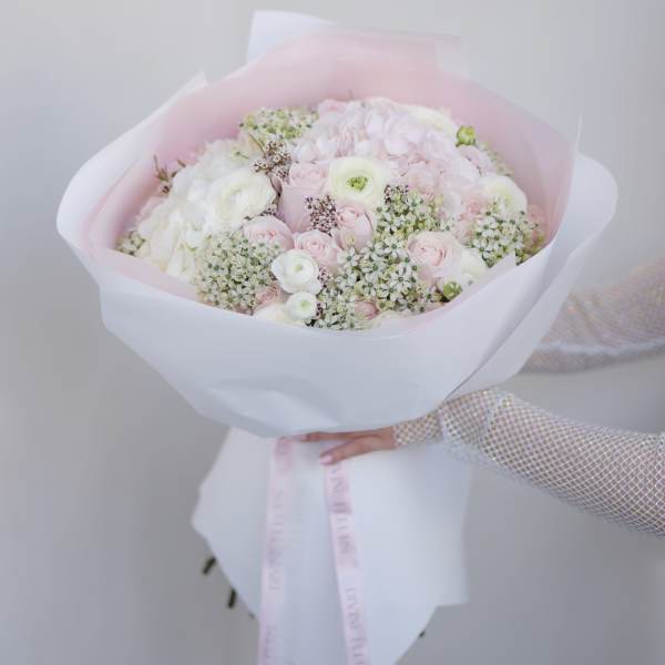 Bouquet of pale pink and white flowers wrapped in pink paper