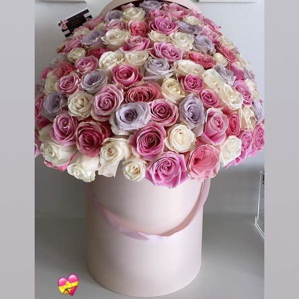 Large round bouquet of pink, white, and lavender roses in a pale pink hat box