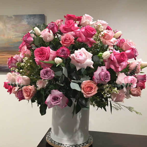 Large bouquet of pink and lavender roses in a white vase