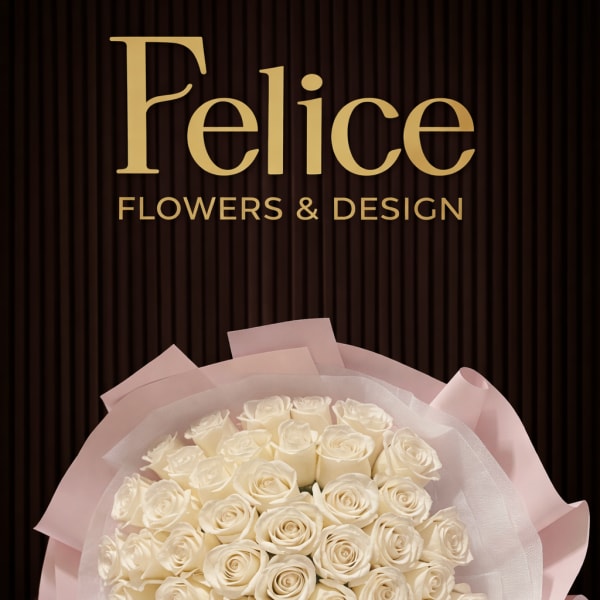 Bouquet of white roses wrapped in pale pink paper with a ribbon