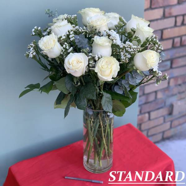 White roses arranged in a clear glass vase