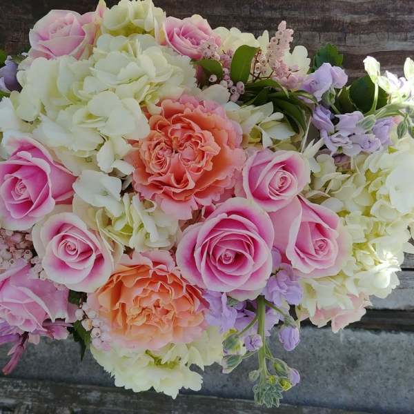 Pink and peach roses with white hydrangeas in a bouquet