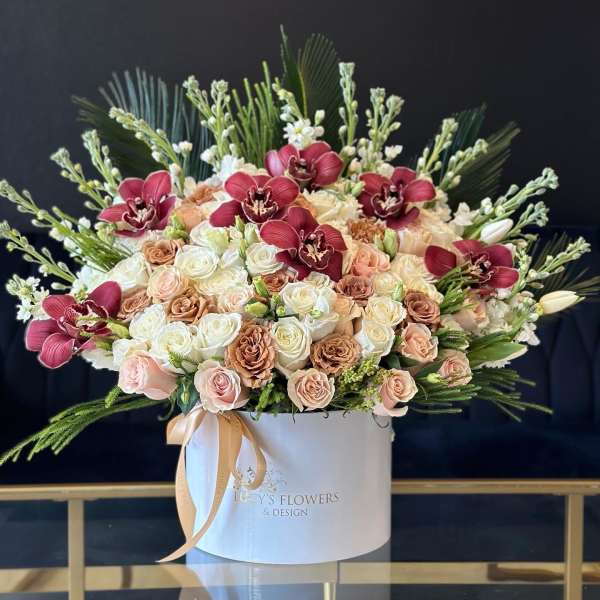 Large rose arrangement with burgundy orchids in a white hat box