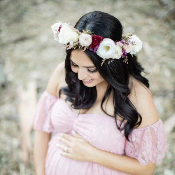 Pregnant woman in a pink dress wearing a floral crown