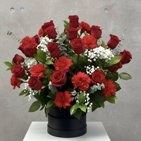 Red roses and carnations arranged in a black box