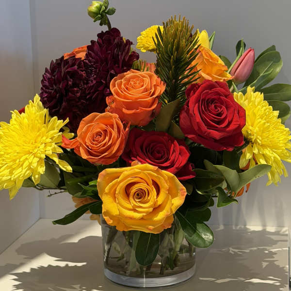 Mixed bouquet of roses and chrysanthemums in a clear glass vase