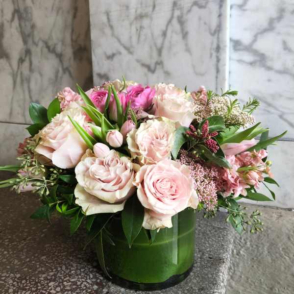 Pink and white roses arranged in a green vase
