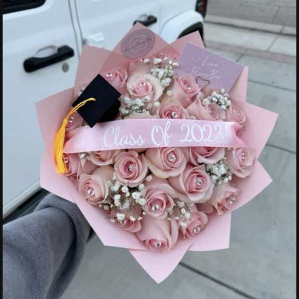 Pink rose bouquet with a graduation cap and Class of 2023 ribbon