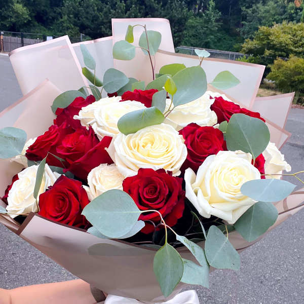 Bouquet of red and white roses with eucalyptus in beige wrap