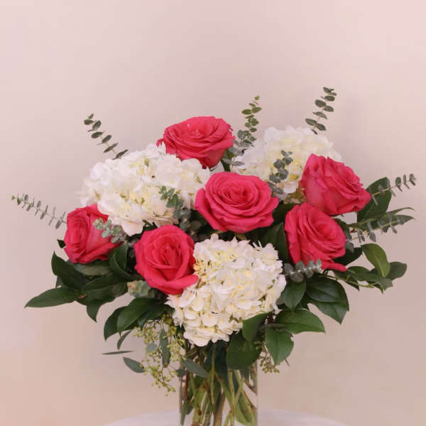 Pink roses and white hydrangeas in a clear glass vase