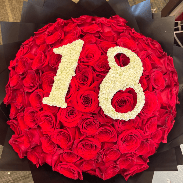 Round bouquet of red roses with cream-colored numbers 78 on top