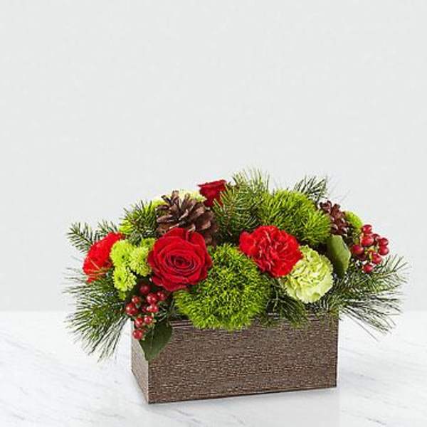 Red roses and carnations in a rectangular box with pine and berries