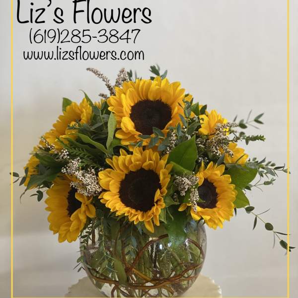 Sunflower arrangement in a round glass vase
