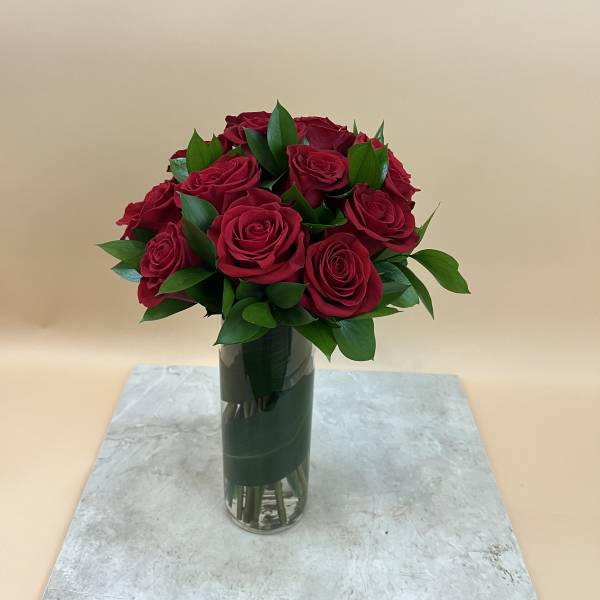 Bouquet of red roses in a tall glass vase