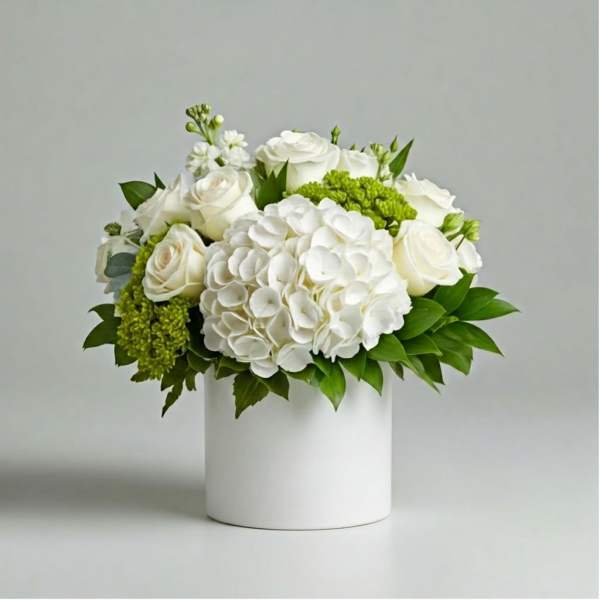 White roses and hydrangeas in a white cylindrical vase