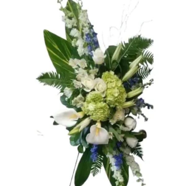 Tall floral arrangement with white calla lilies, green hydrangeas, and blue accents