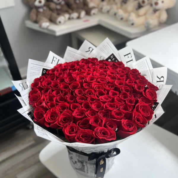Large bouquet of red roses wrapped in black-and-white paper