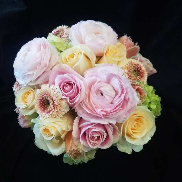 Bouquet of pale pink and cream roses with ranunculus and small daisy-like blooms