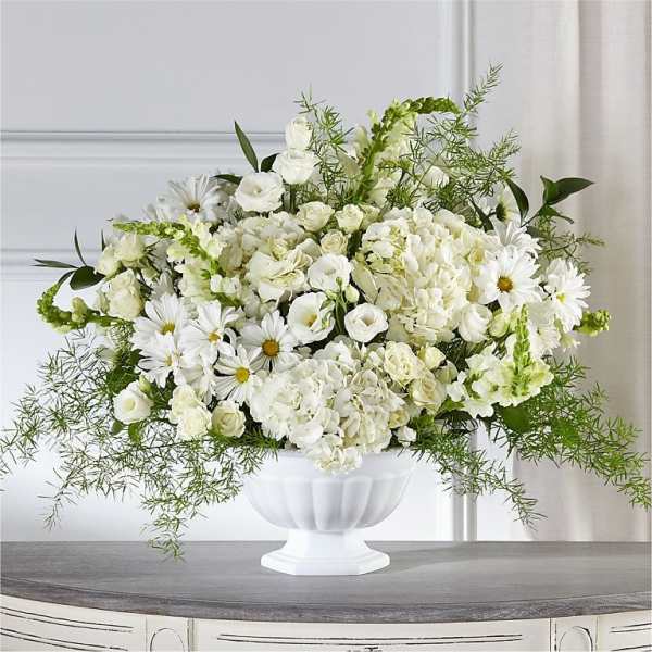 White floral arrangement in a white pedestal vase