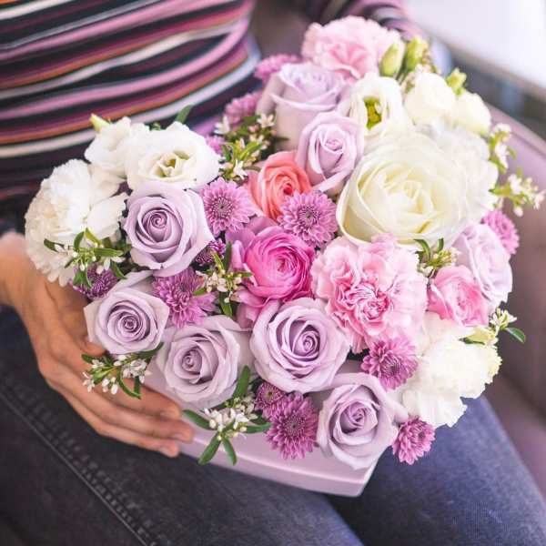 Handheld bouquet of pink, lavender, and white flowers