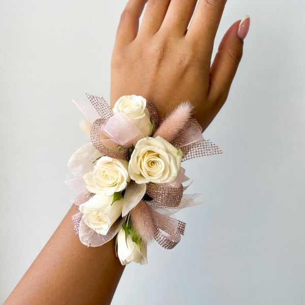 Cream rose wrist corsage with pink ribbon and mesh accents