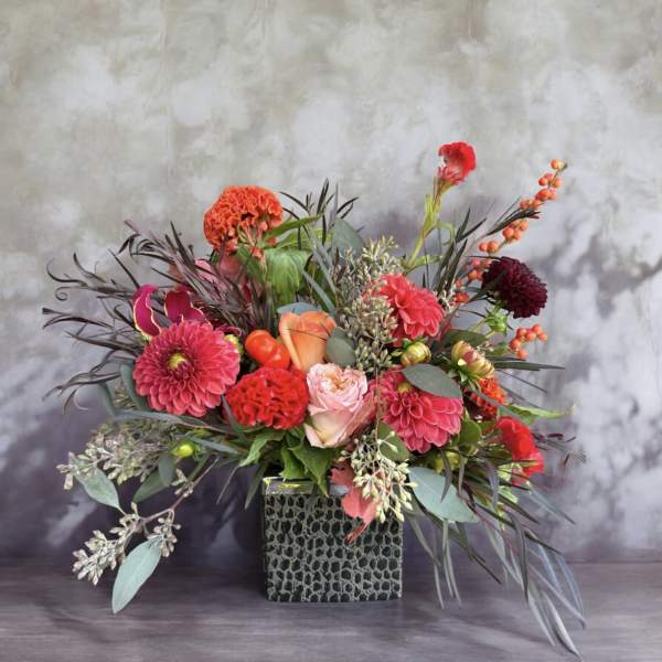 Bright mixed flower arrangement in a square textured vase