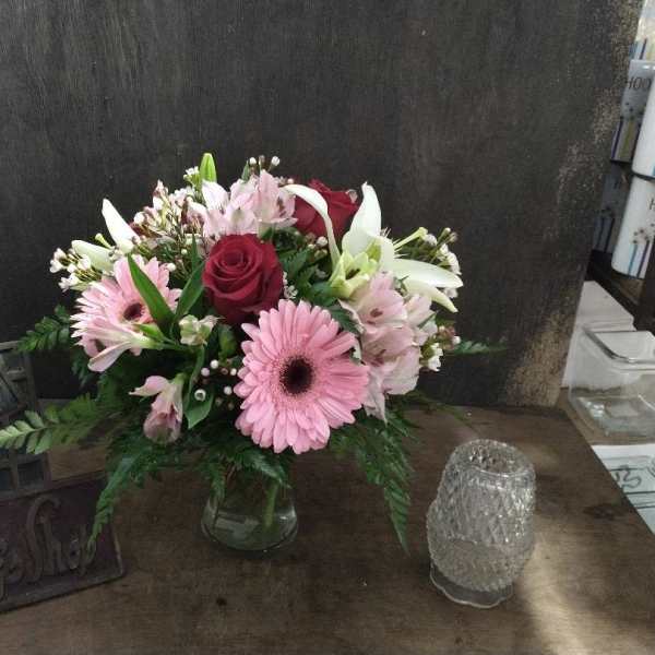 Pink and white mixed flower arrangement in a glass vase