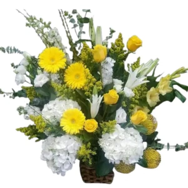 Yellow and white mixed flower arrangement in a woven basket