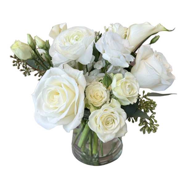 White roses and calla lilies arranged in a glass vase