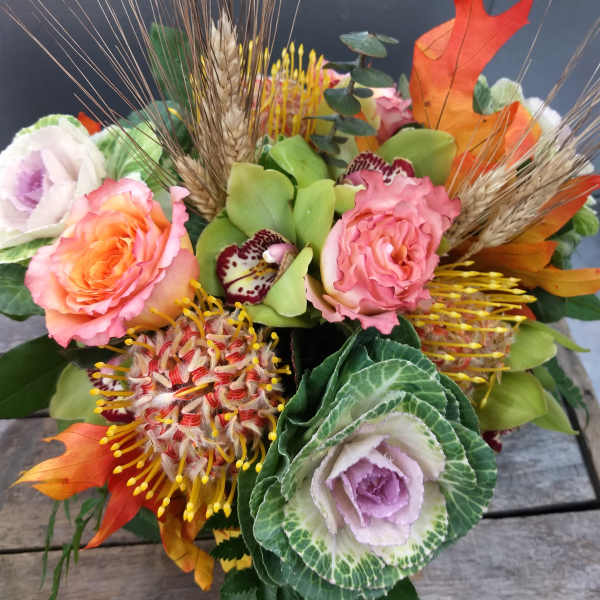 Mixed bouquet with pink roses, ornamental kale, and autumn accents