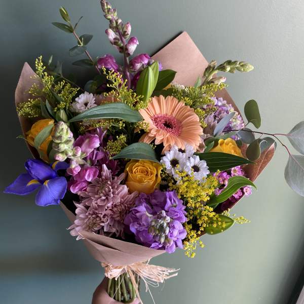 Hand-tied bouquet with pink, purple, yellow, and peach flowers