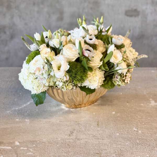 White floral arrangement in a gold bowl vase