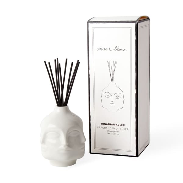 White skull-shaped diffuser bottle with black reeds beside its box
