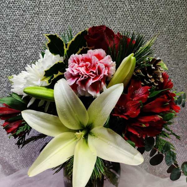 Bouquet of lilies, carnations, roses, and daisies in a glass vase
