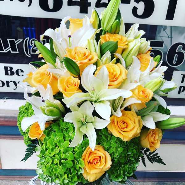 Bouquet of yellow roses and white lilies with green hydrangeas