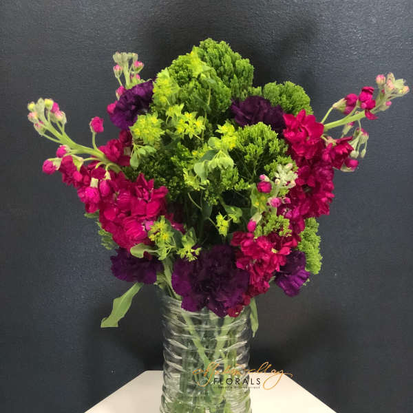 Bright pink and purple flowers in a clear glass vase