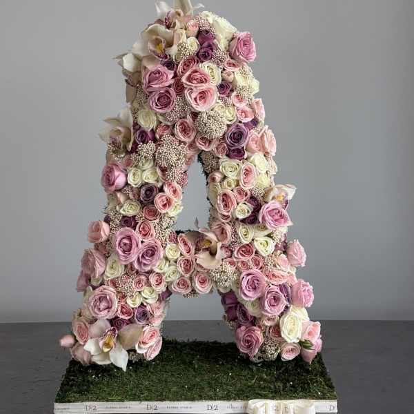 Large floral letter A covered in pink and white roses and orchids