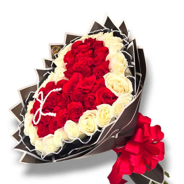 Bouquet of red and white roses wrapped in dark paper with a red ribbon