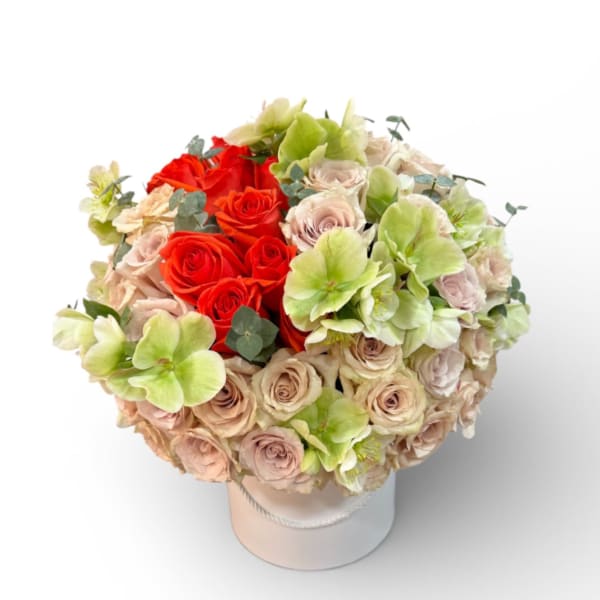 Bouquet of red and blush roses with pale green blooms in a white hat box