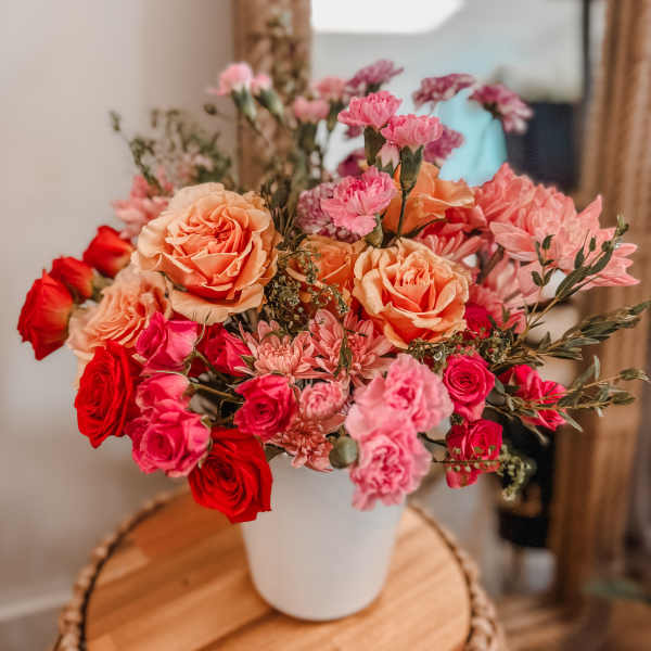 Bouquet of pink and peach roses in a white vase