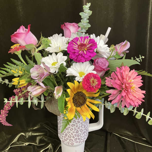 Mixed bouquet in a leopard-print tumbler with pink, white, and yellow flowers