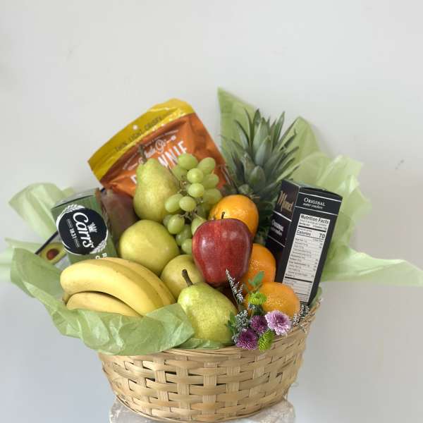 Fruit basket with bananas, pears, grapes, oranges, and snack boxes