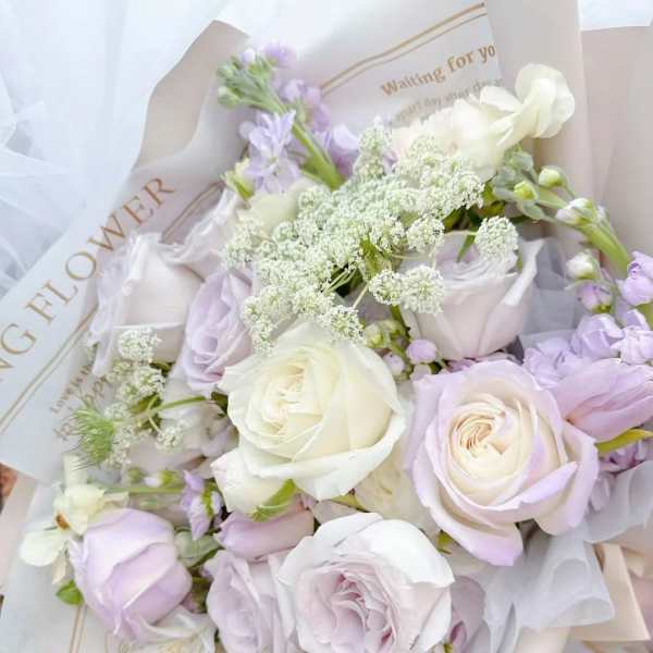 Bouquet of pale lavender and white roses with airy filler flowers