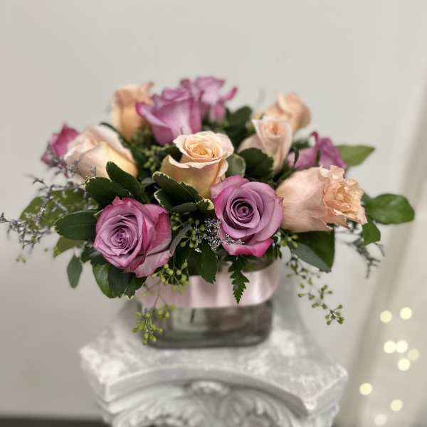 Arrangement of pink and peach roses in a glass vase