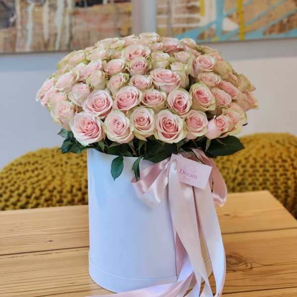 Large bouquet of pale pink roses in a white hat box with a pink ribbon