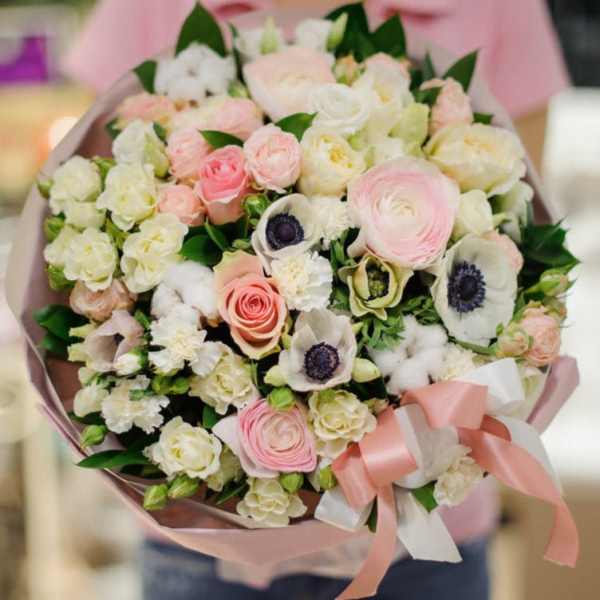 Bouquet of pale pink and white flowers wrapped in pink paper