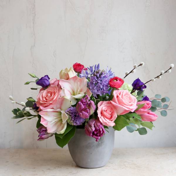 Pink and purple mixed flower arrangement in a gray vase