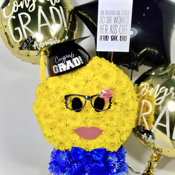 Yellow flower graduation face arrangement with balloons and a sign